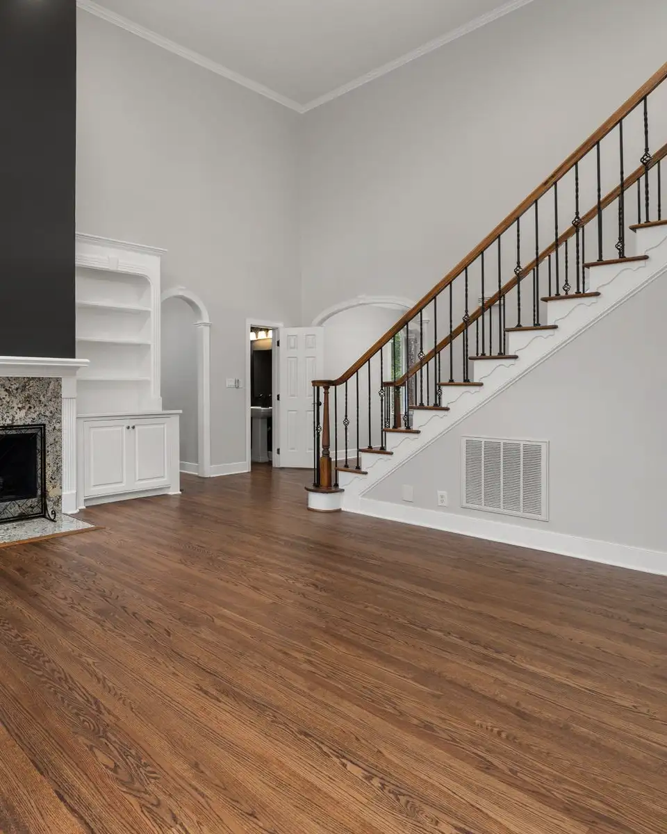 Living room with built-in shelves around a fireplace and a staircase to one side